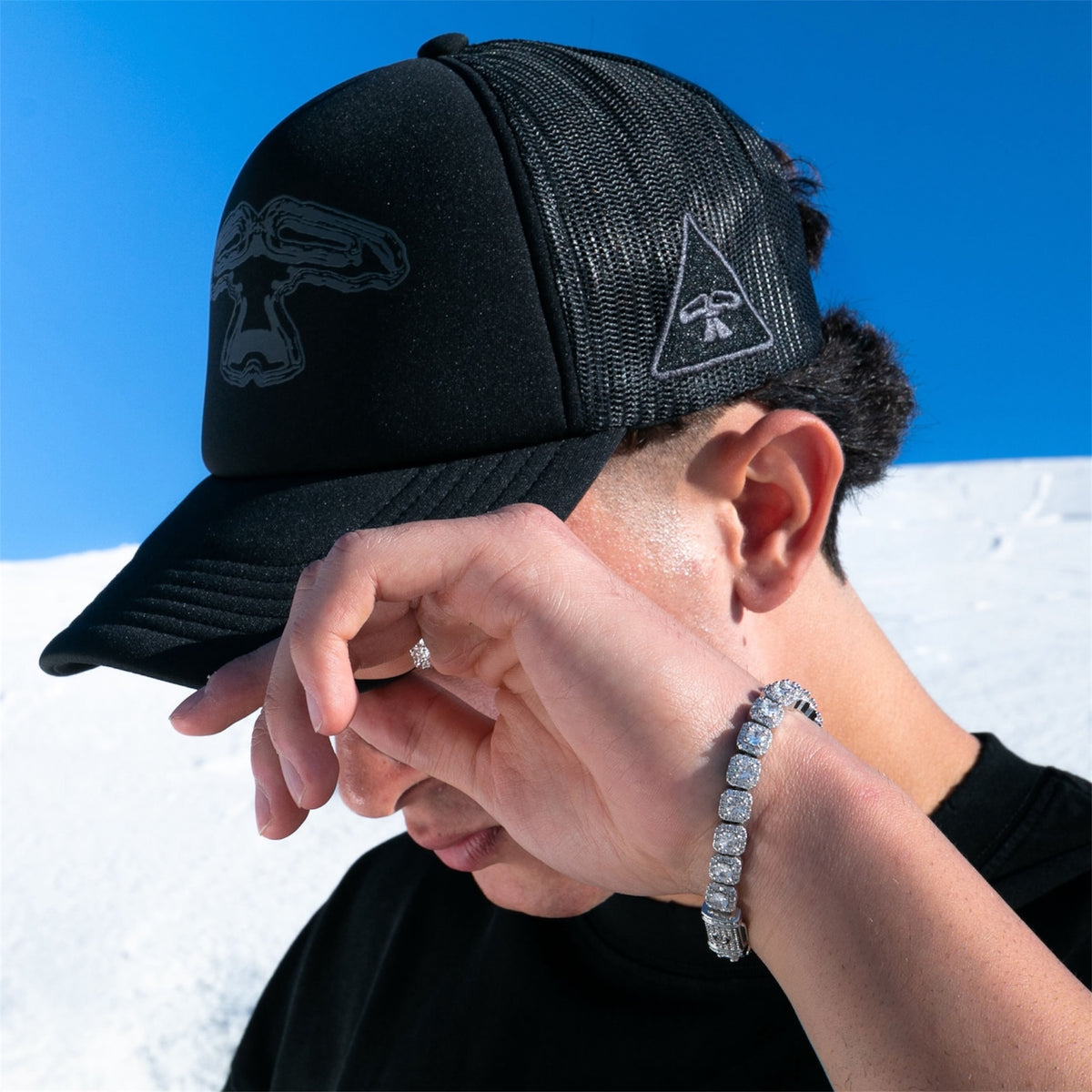 Model wearing the 5Loop Cap Tribullets black trucker cap, side view